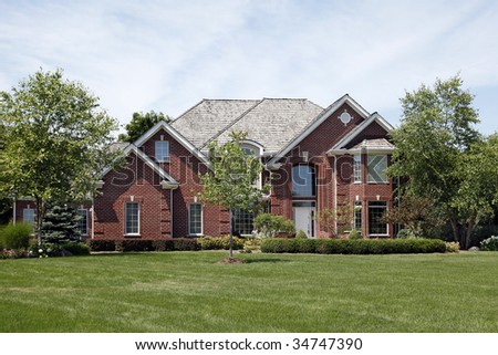 Large brick home in suburbs with cedar roof
