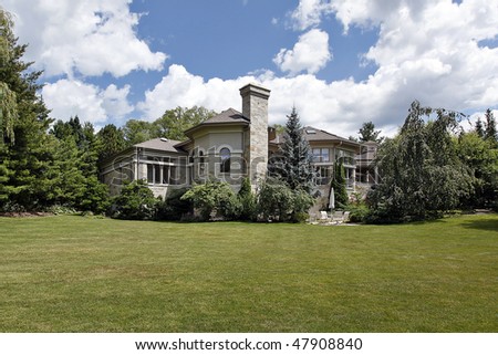 Large suburban stone home with terrace and patio