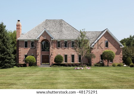 Luxury brick home in suburbs with arched entry