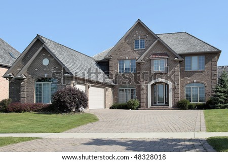 Suburban brick home with arched entry and three car garage