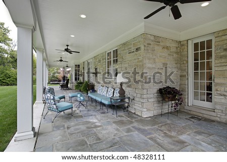 Blue stone patio with columns and blue furniture