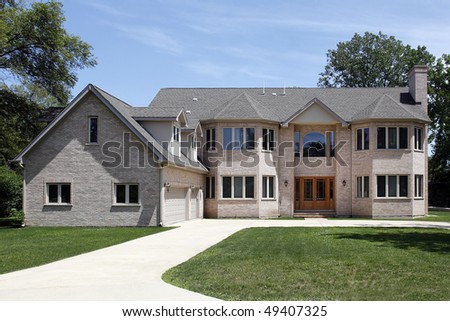 Large brick home in suburbs with three car garage