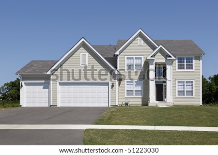 Suburban home with tan siding and arched entry