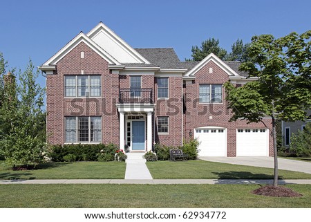 Brick home with front balcony and white columns