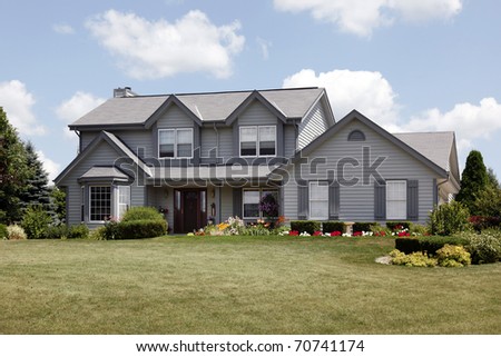 Home in suburbs with gray siding and covered entry