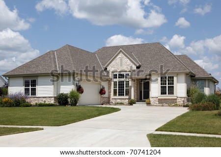 Home with stone entry and cream colored siding