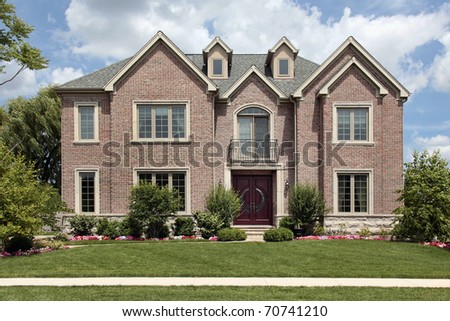 Brick home in suburbs with front balcony