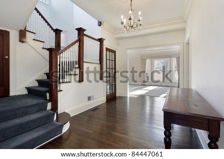 Foyer in traditional home with brown and white staircase