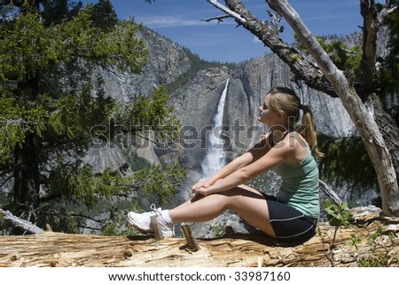 Young woman  looking at Yosemite Falls in the Sierra Nevada mountains of California