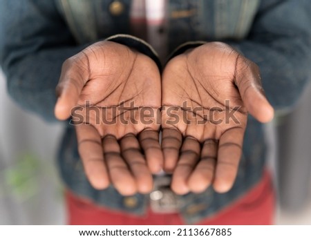 Close up open hands of a young african american man wearing denim jacket. Begging hands of a poor man concept. Young african american man with outstretched hands begging for money for life. 商業照片 © 