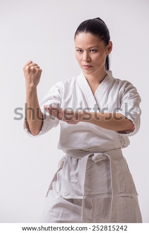 Asian woman in kimono show block in martial art exercise on white