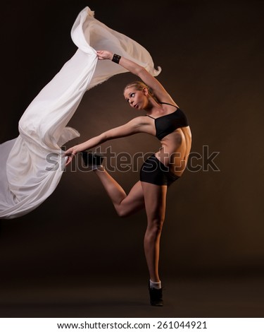 young beautiful blonde woman in motion with fabric in her hands