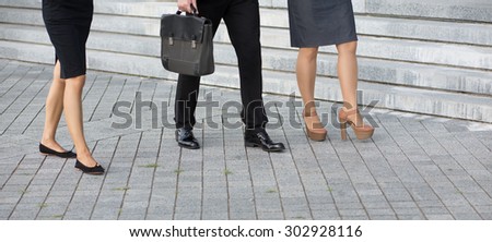 Close-up picture of people\'s legs. Low section of businesspeople walking along the office building after hark work.