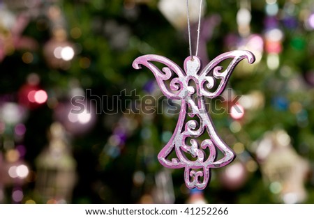christmas toy - beautiful angel with green tree and lights on background