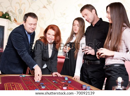Group of people play roulette in casino