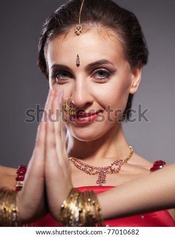 Close up portrait of indian dancer in red dress on grey background