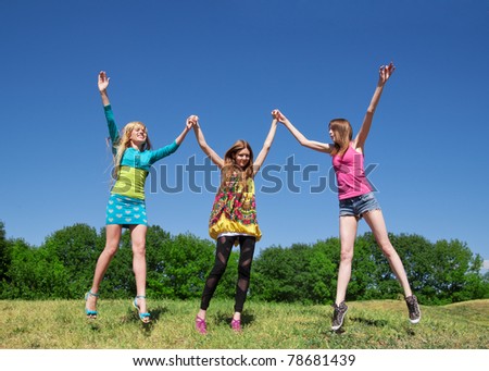 Group of young girls play and express positivity in park