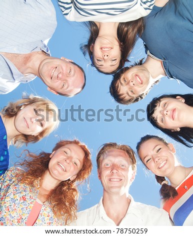 Group of people express positivity across blue sky