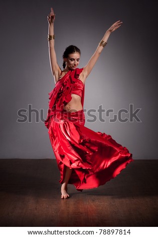 Portrait of Indian dancer in red dress on grey background