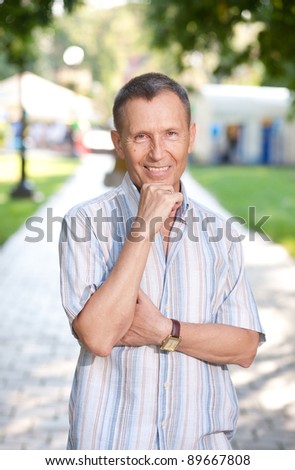 Old man posing for camera in park