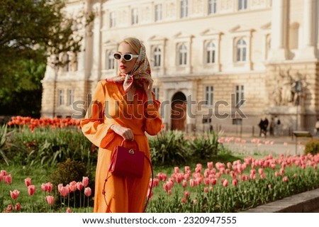 Similar – Foto Bild Stilvolle Frau mit Sonnenbrille posiert an Graffiti-Wand auf Stadtstraße.