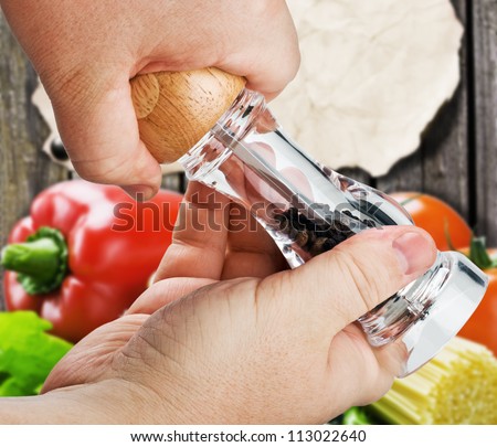 mill for spices in the hands isolated on a background of food