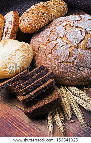 fresh bread and rolls with ears of wheat on the table