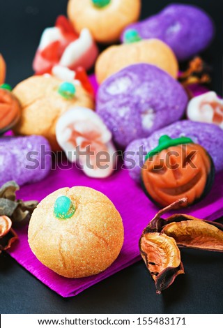 sweets and candies for the holiday Halloween. Focus on the pumpkin in the foreground