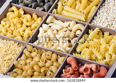 assortment of pasta in a wooden box background