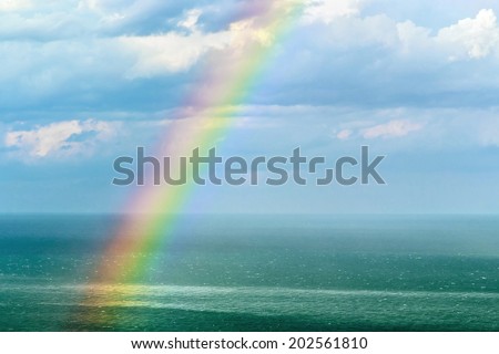 beautiful landscape with a rainbow after the rain. focus on the waves in front of the frame and rainbow