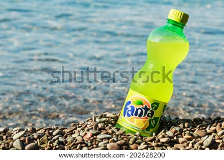 YALTA, Crimea - June 9, 2014: Fanta bottle on the beach. Fanta soft A highly refreshing drink with orange flavor, a trademark owned by The Coca-Cola Company