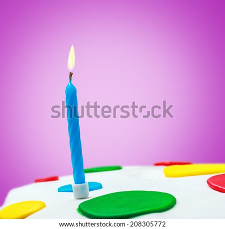 Lighted candles on a birthday cake on a purple background