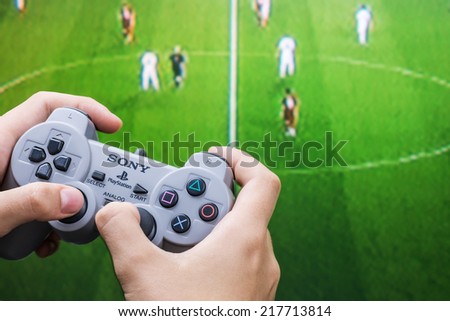 Moscow, Russia - September 11, 2014: Teenager playing football on the Playstation. Playstation game console of the fifth generation, developed by Sony Computer Entertainment Ken Kutaragi-led