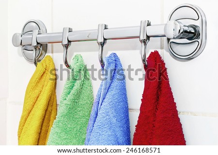 colored towels hanging on the rack in the bathroom. focus on blue towel
