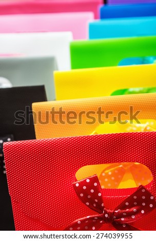 colorful shopping bags background. Focus on the foreground, on a red bag