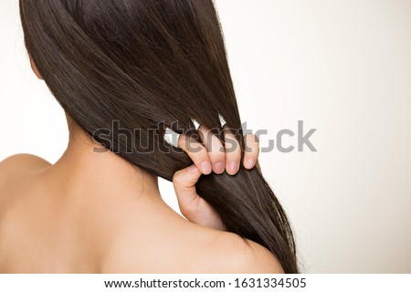 Similar – Image, Stock Photo Long-haired brunette Asian woman dressed in a white sweater, looking in the mirror and combing her hair