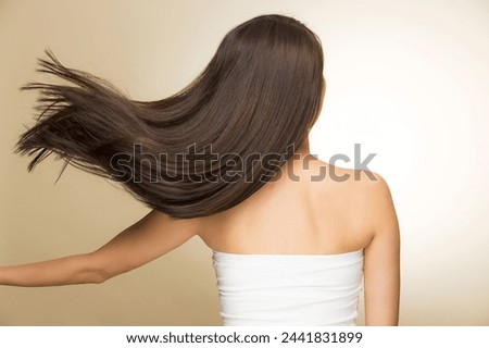 Similar – Image, Stock Photo Long-haired brunette Asian woman dressed in a white sweater, looking in the mirror and combing her hair