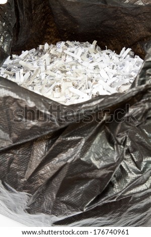Thin strips of shredded paper in a black plastic bag