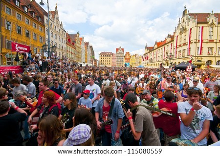WROCLAW - MAY 1: A crowd of people plays guitars in a Wroclaw market square at the \