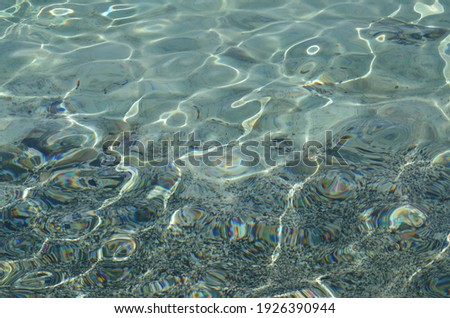 Rippling sea water surface with sun glare. Nature background texture. Golden beach, Chrissi island, Greece.