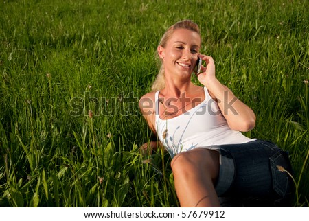 young woman is in the meadow and make phone calls