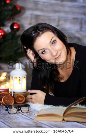 Brunette reading a book on a winter evening