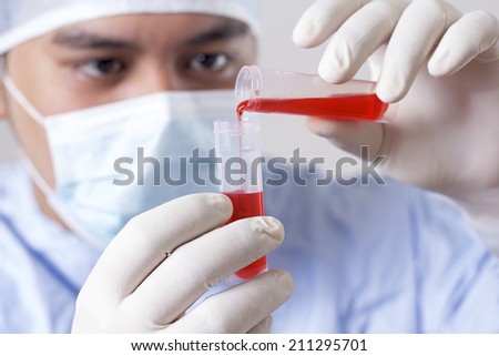 Scientist carefully mixing chemicals at the laboratory.