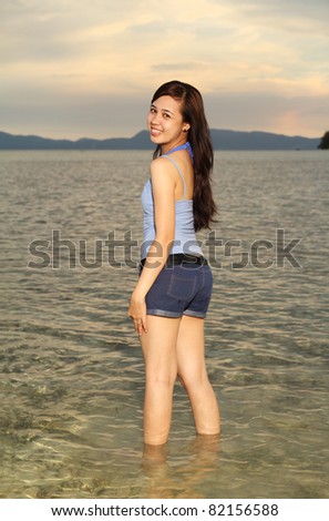 Happy young lady enjoying a walk by the sea