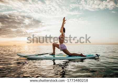 Image, Stock Photo Serene woman on surfboard in sea