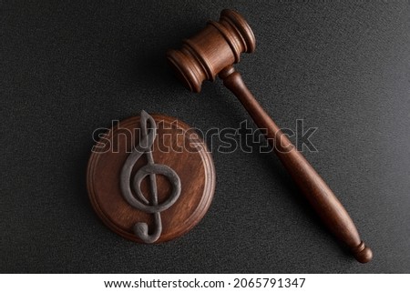 Music symbol treble clef and judge gavel on black background. Music copyright infringement. Music piracy ストックフォト © 