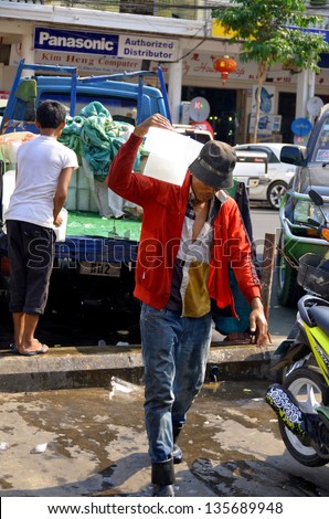 PHNOM PHEN CAMBODIA MARCH 26: Young man delivery ice a the central market on march 26 2013 in Phnom Phen Cambodia. Because lack of refrigeration in Cambodia, ice is manufactured centrally.