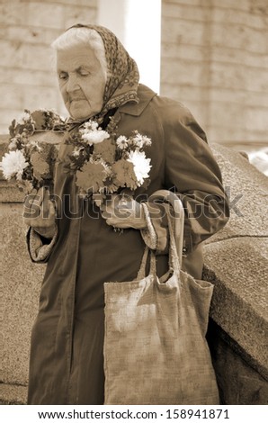 SOFIA BULGARIA SEPTEMBER 22: Old woman selling flowers for help to live in front the  St Nedelya Church on september 22 2013 in Sofia Bulgaria