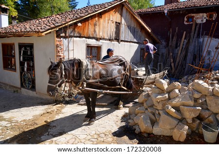 KOPRIVSHTITSA BULGARIA SEPTEMBER 25: Men restore old houses help by an horse on september 25 2013 in Koprivshtitsa Bulgaria