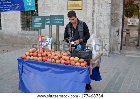 STANBUL TURKEY SEPT 28: Young man sells pomegranate juice for to live in down town Istanbul on september 28 2013. Pomegranate juice is one of the most popular in Turkey